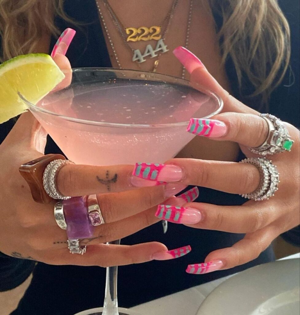 femme avec longs ongles plus verre en main.