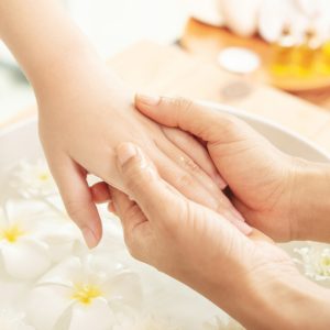Beautician massaging hand of female spa salon client. Spa treatm massage des mains